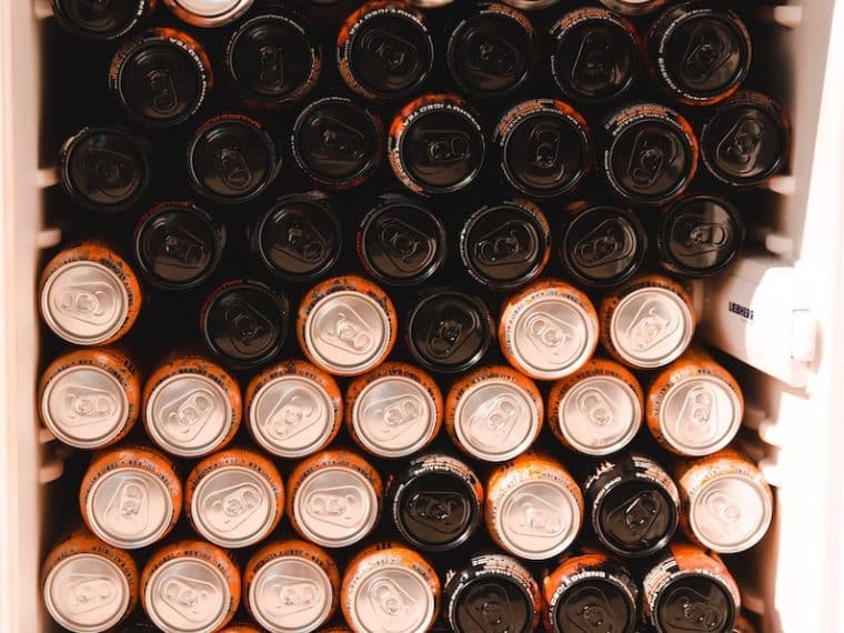 black and brown energy drink cans in white refrigerator